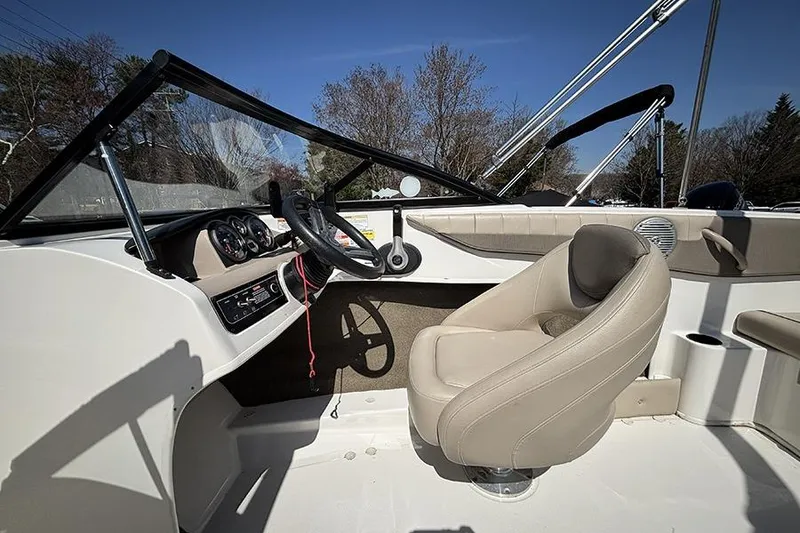 Slide: The Image of 2016 Bayliner 185 Bowrider interior with steering wheel and beige seating. - 12