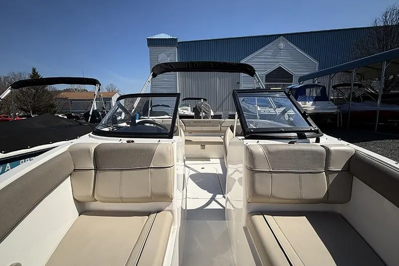 Slide: The Image of 2016 Bayliner 185 Bowrider interior with beige seating, parked outdoors. - 19