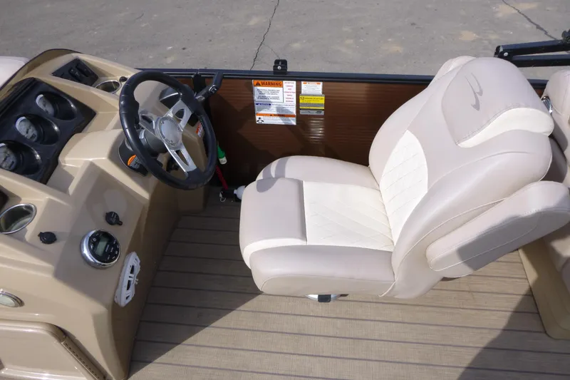 Slide: The Image of 2018 Bennington 24 SSRX boat interior with beige captain's chair and steering console. - 11