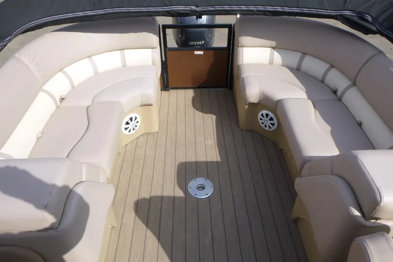 Slide: The Image of 2018 Bennington 24 SSRX boat interior with beige seating and wood-style flooring. - 14