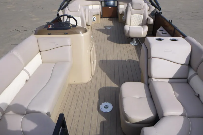Slide: The Image of 2018 Bennington 24 SSRX pontoon boat interior with beige seating and steering console. - 6