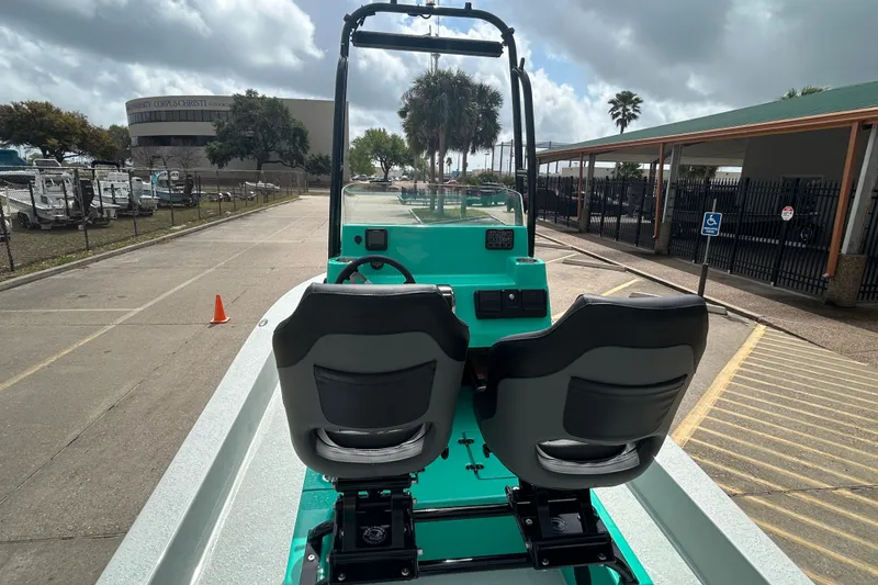 Slide: The Image of 2026 Gulf Coast Saber Cat boat with dual seats, parked outdoors under cloudy skies. - 11