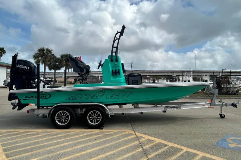 Slide: The Image of 2026 Gulf Coast Saber Cat boat on trailer, featuring Suzuki engine, parked outdoors. - 5