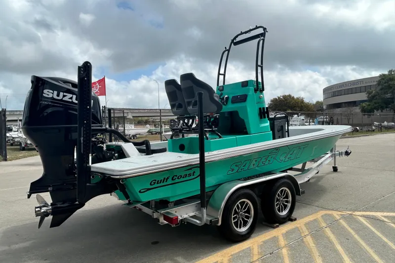 Slide: The Image of 2026 Gulf Coast Saber Cat boat with Suzuki engine on trailer, parked outdoors. - 6