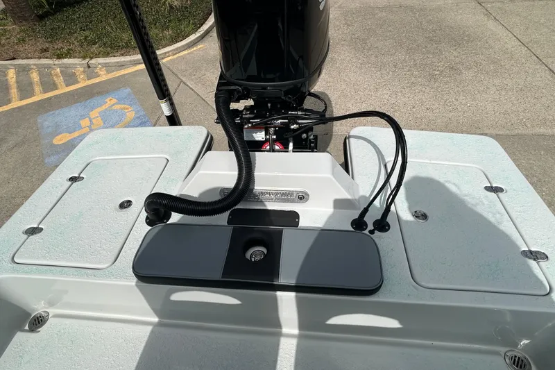 Slide: The Image of 2026 Gulf Coast Saber Cat boat deck with motor and storage compartments. - 9