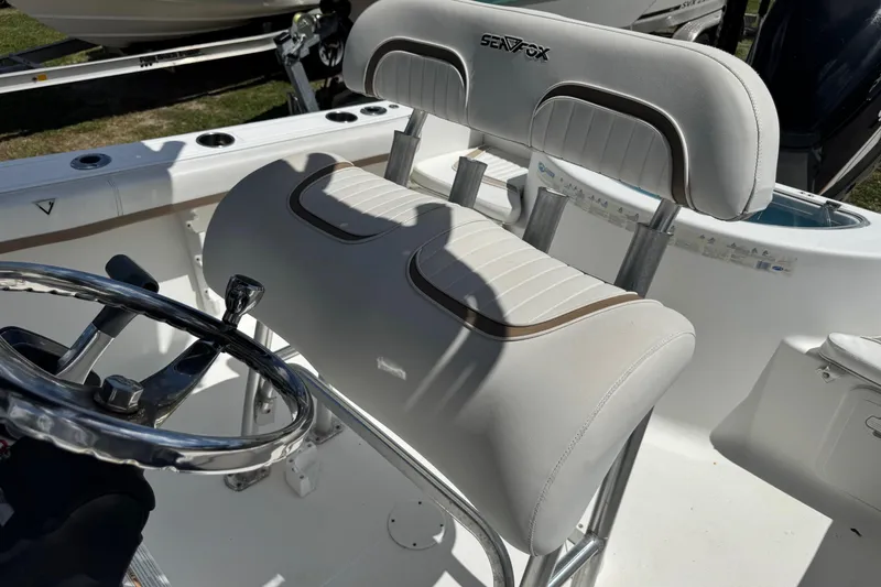 Slide: The Image of 2008 Sea Fox 216 Center Console boat interior with steering wheel and cushioned seating. - 16