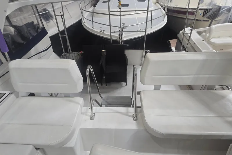 Slide: The Image of 1999 Carver 326 Aft Cabin Motor Yacht interior with white seating and metal railings. - 11