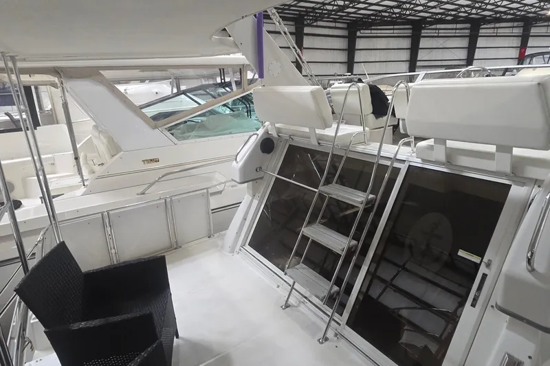 Slide: The Image of 1999 Carver 326 Aft Cabin Motor Yacht interior with seating and ladder in a showroom. - 16