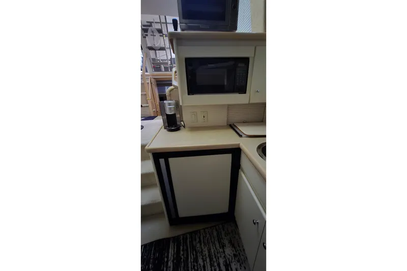 Slide: The Image of Compact kitchen area in a 1999 Carver 326 Aft Cabin Motor Yacht with microwave and coffee maker. - 23