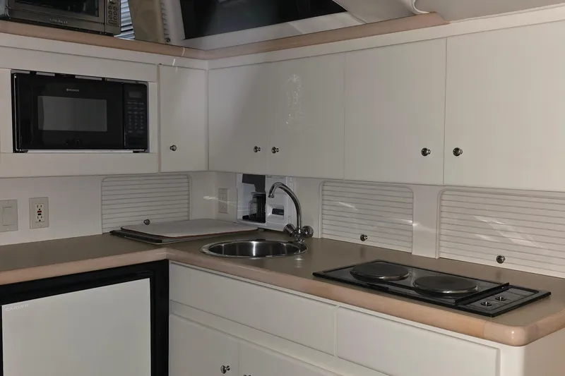 Slide: The Image of 1999 Carver 326 Aft Cabin Motor Yacht kitchen with microwave, sink, and stovetop. - 43