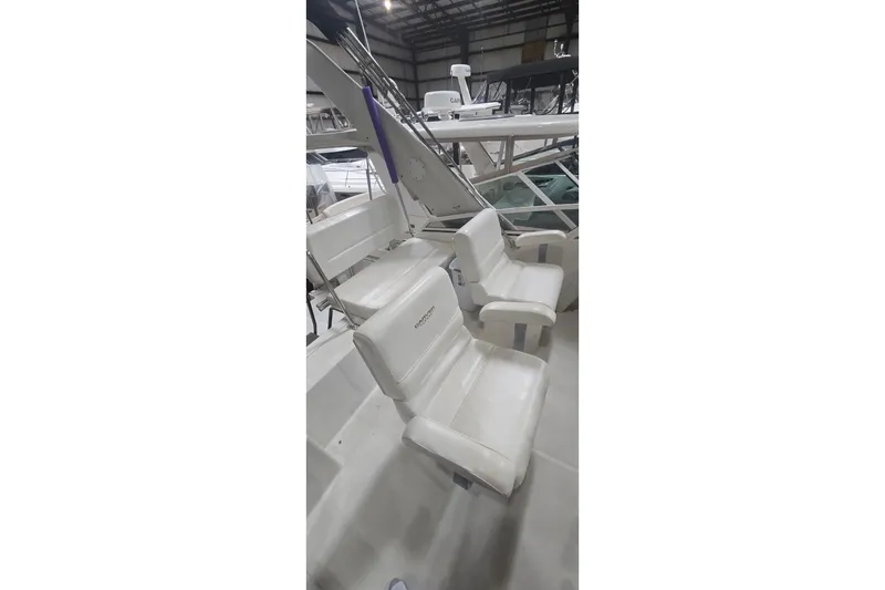 Slide: The Image of 1999 Carver 326 Aft Cabin Motor Yacht interior with white seating in a marina setting. - 8