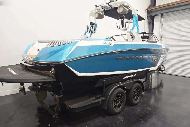 Slide: The Image of 2017 Nautique Super Air Nautique G23 boat in a showroom, blue and white design. - 11