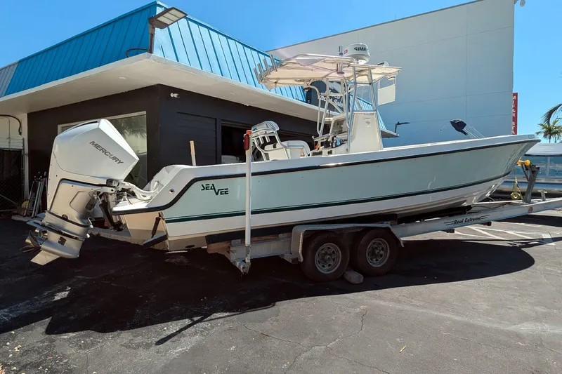 Slide: The Image of 2005 SeaVee 290B boat on trailer with Mercury outboard, parked near a building. - 2