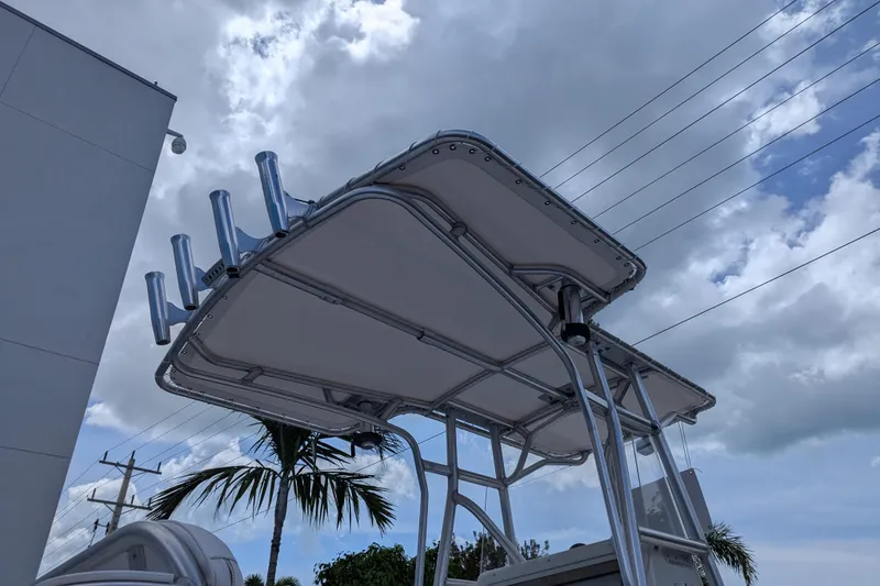 Slide: The Image of 2005 SeaVee 290B boat with T-top against cloudy sky and palm tree background. - 28