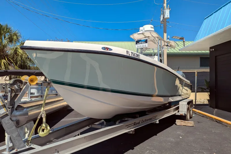 Slide: The Image of 2005 SeaVee 290B boat on trailer, parked outdoors under clear blue sky. - 3