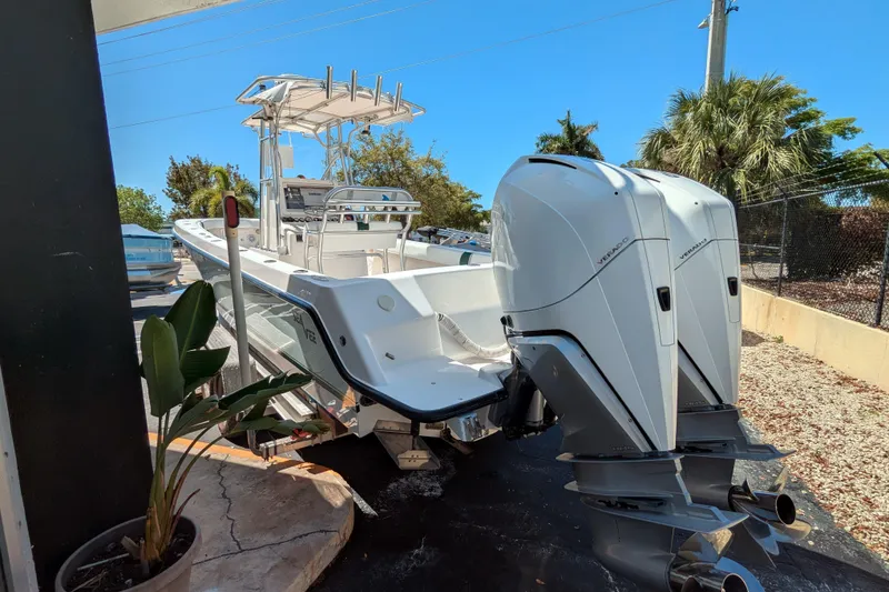 Slide: The Image of 2005 SeaVee 290B boat with dual outboard engines, parked outdoors under clear blue sky. - 5