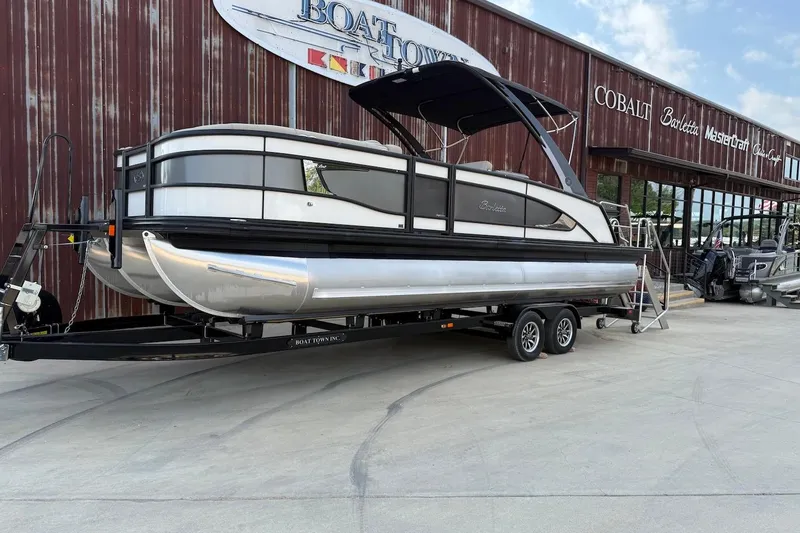 Slide: The Image of 2022 Barletta LUSSO 25UEA pontoon boat on trailer outside dealership. - 1