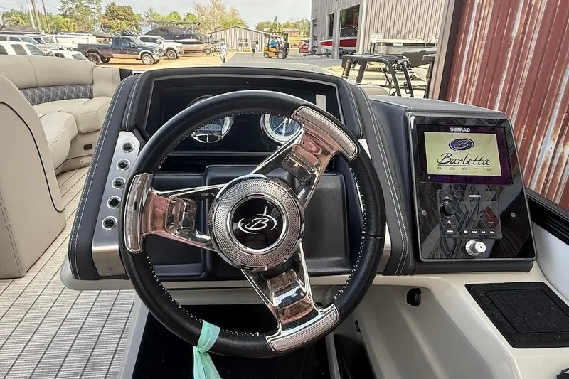 Slide: The Image of 2022 Barletta LUSSO 25UEA boat dashboard with steering wheel and digital display. - 9