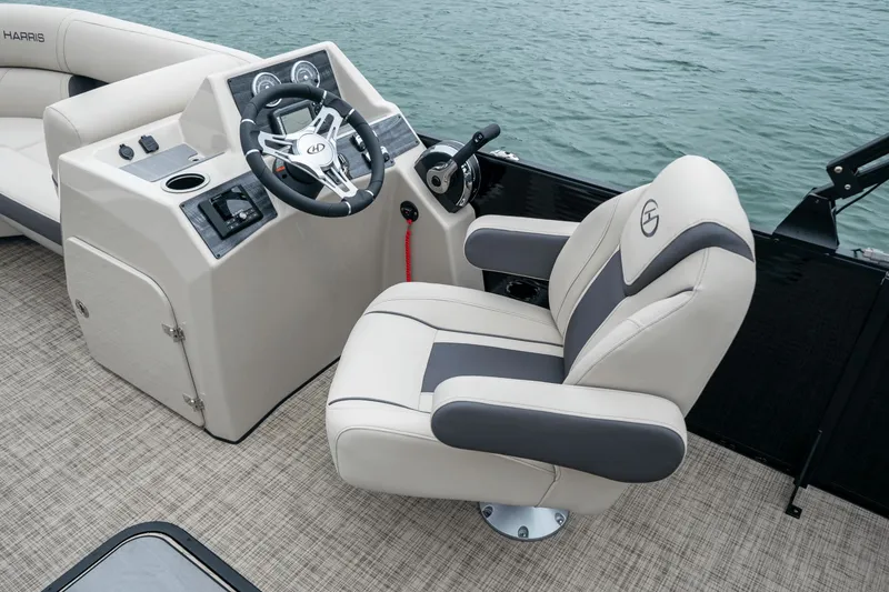 Slide: The Image of The image shows the cockpit of a 2026 Harris Cruiser 210 with a beige helm seat. - 16