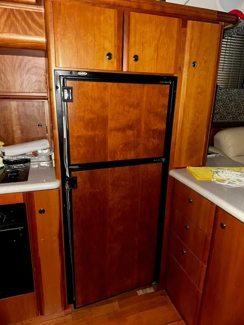 Slide: The Image of Kitchen area of 2002 Silverton 39 Motor Yacht with wooden cabinets. - 26
