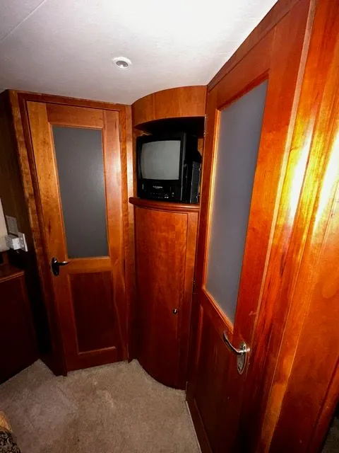 Slide: The Image of Interior of 2002 Silverton 39 Motor Yacht with wooden doors and TV. - 34