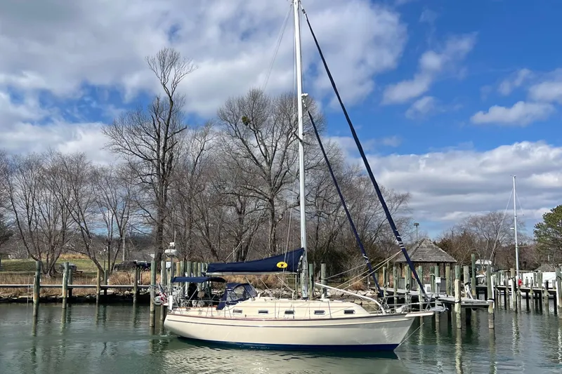 The Image of 1998 Island Packet 350 sailboat docked in a marina under a partly cloudy sky. - 0