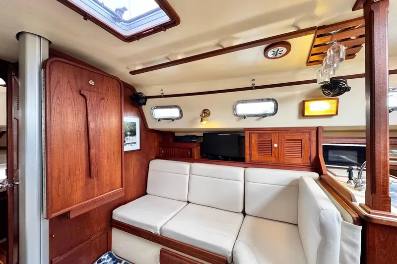 Slide: The Image of Interior of 1998 Island Packet 350 sailboat with wood finishes and compact kitchen area. - 10