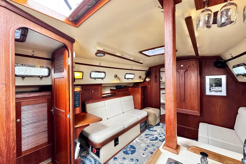 Slide: The Image of Interior of 1998 Island Packet 350 sailboat with wood finish and white seating. - 11
