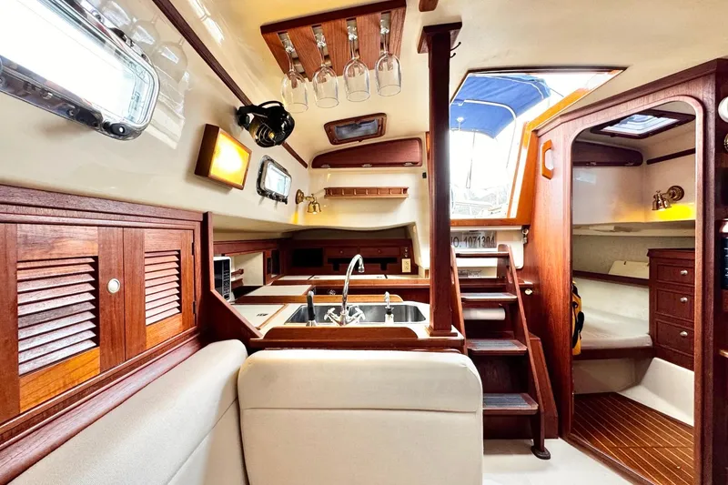 Slide: The Image of Interior of 1998 Island Packet 350 sailboat with cozy dining area and wooden cabinetry. - 12