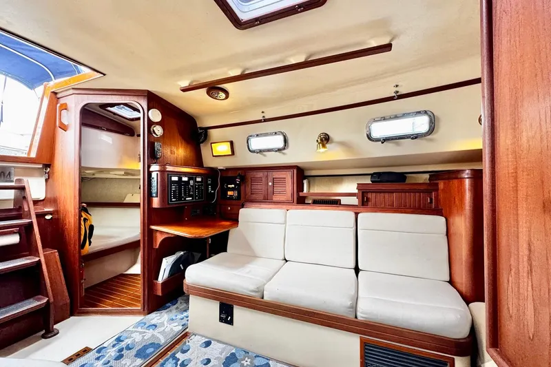 Slide: The Image of Interior of a 1998 Island Packet 350 sailboat with wood finishes and cozy seating. - 13