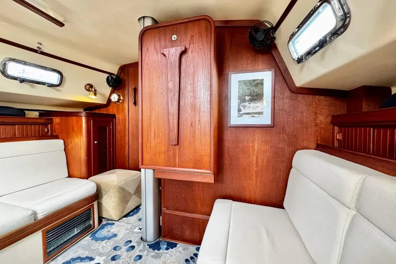 Slide: The Image of Interior of 1998 Island Packet 350 sailboat with wooden cabinetry and cozy seating area. - 14
