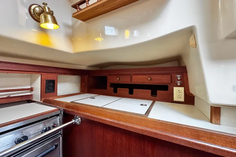 Slide: The Image of Interior of 1998 Island Packet 350 sailboat with wood finish and white seating. - 17