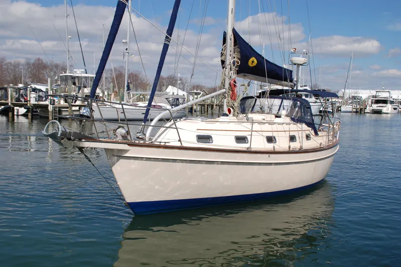 Slide: The Image of 1998 Island Packet 350 sailboat docked in a marina, surrounded by other boats. - 2