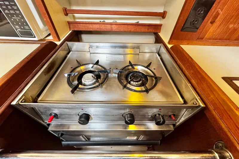 Slide: The Image of Interior view of a 1998 Island Packet 350 sailboat's storage compartment with wooden trim. - 22