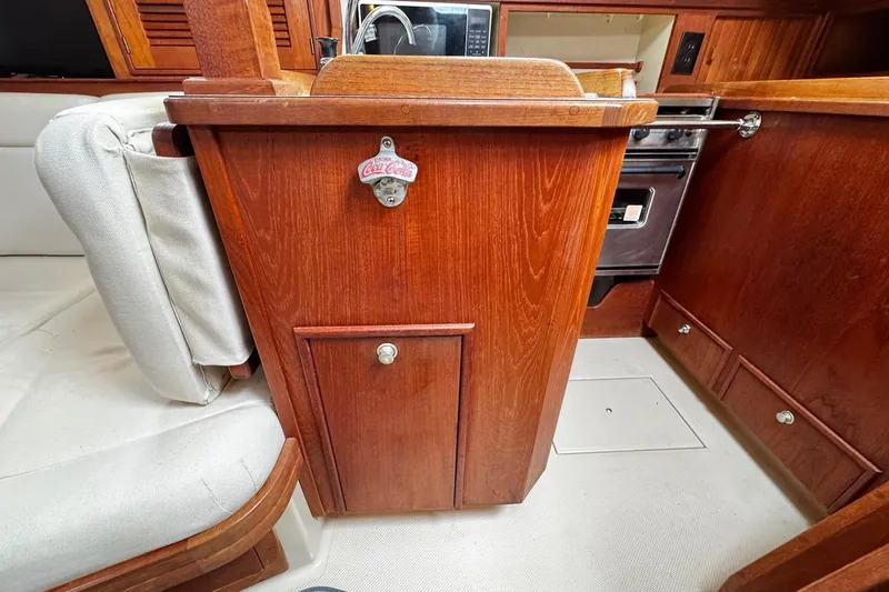 Slide: The Image of Interior view of a 1998 Island Packet 350 sailboat, featuring wooden cabinetry and storage compartments. - 23