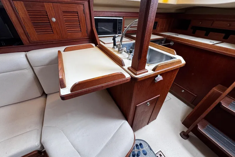 Slide: The Image of Interior of 1998 Island Packet 350 sailboat with wooden cabinetry and Coca-Cola bottle opener. - 25
