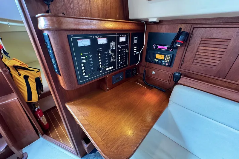Slide: The Image of Interior of a 1998 Island Packet 350 sailboat, featuring wood cabinetry and cozy seating. - 26