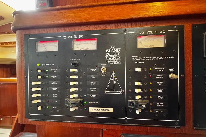 Slide: The Image of Navigation station of a 1998 Island Packet 350 sailboat with control panels and radio equipment. - 28