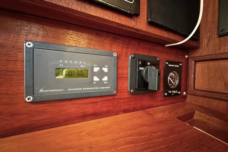 Slide: The Image of Interior of 1998 Island Packet 350 sailboat with wooden cabinetry and control panel. - 29