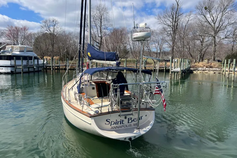 Slide: The Image of 1998 Island Packet 350 sailboat docked in a marina under a clear blue sky. - 3