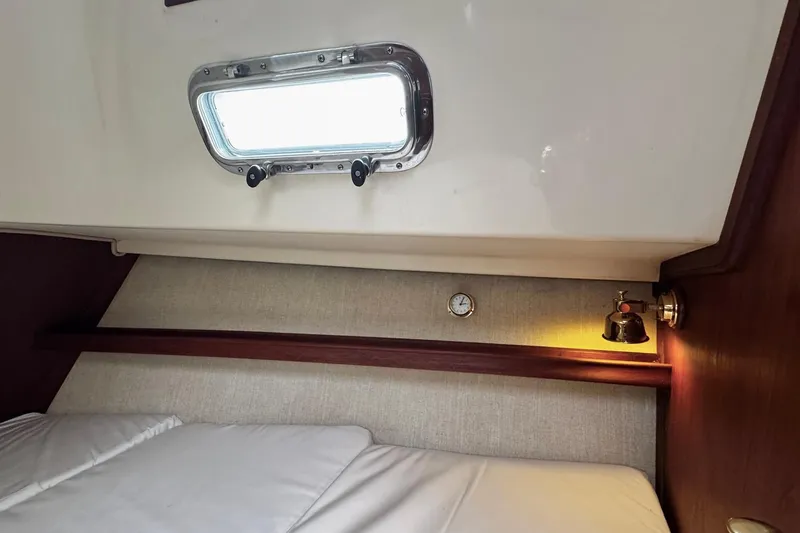 Slide: The Image of Cozy cabin interior of 1998 Island Packet 350 sailboat with wooden furnishings and bed. - 36