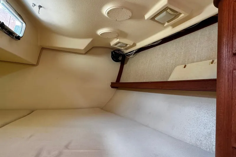 Slide: The Image of Interior of 1998 Island Packet 350 sailboat with wooden cabinetry and cozy sleeping area. - 44
