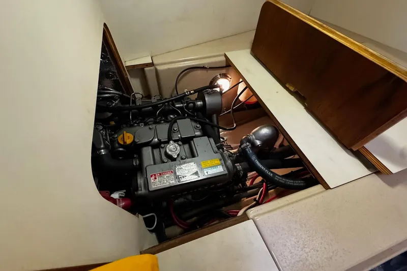 Slide: The Image of Engine compartment of a 1998 Island Packet 350 sailboat, featuring hoses and mechanical components. - 51