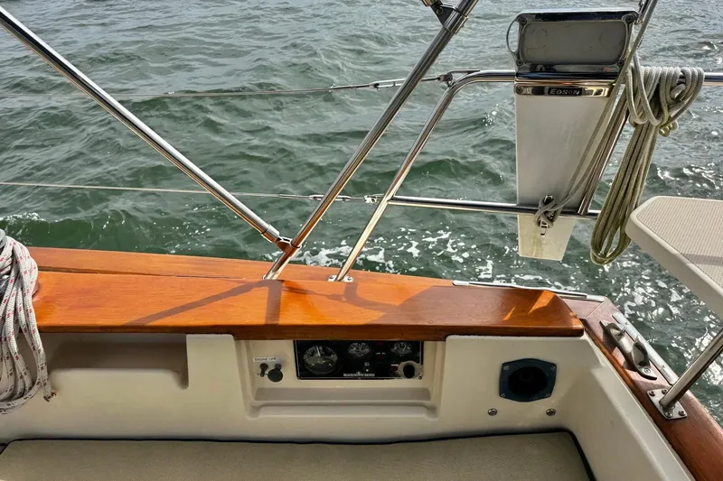 Slide: The Image of 1998 Island Packet 350 sailboat cockpit with ropes and winch, sailing on open water. - 56