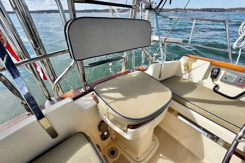 Slide: The Image of Cockpit of 1998 Island Packet 350 sailboat with cushioned seating and steering wheel. - 70