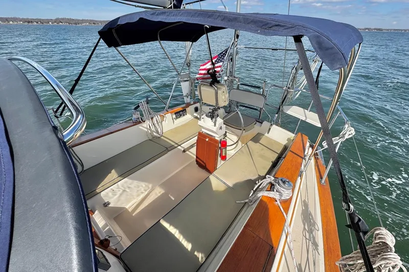 Slide: The Image of Cockpit of 1998 Island Packet 350 sailboat with wooden table and steering wheel. - 79