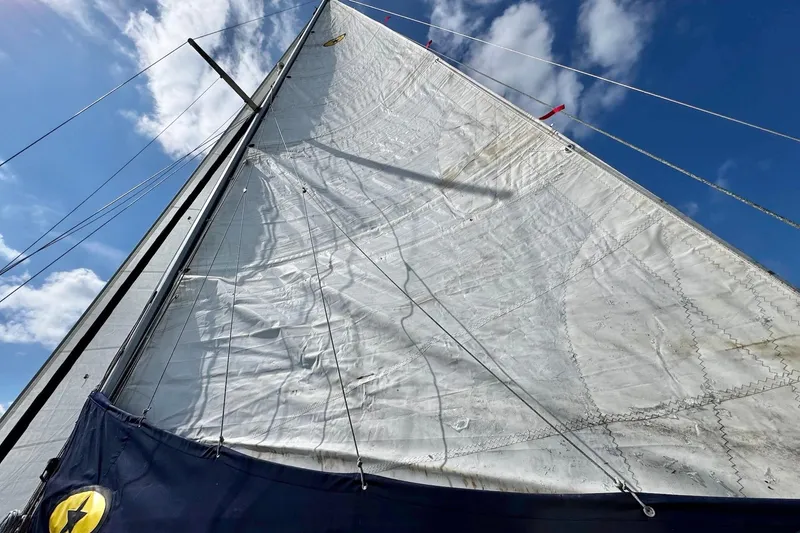 Slide: The Image of 1998 Island Packet 350 sailboat cockpit with canopy, steering wheel, and American flag on open water. - 81