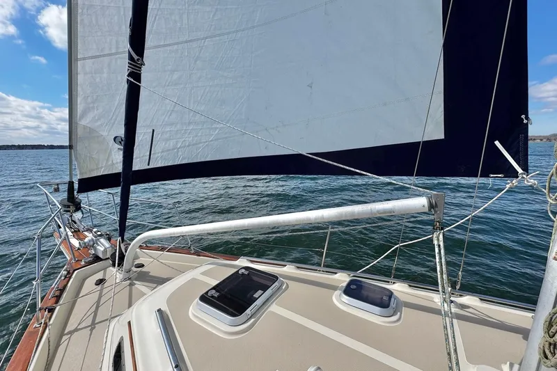 Slide: The Image of 1998 Island Packet 350 sailboat deck with ropes and hatches on open water. - 87