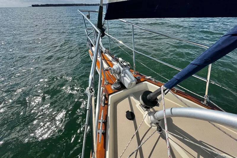 Slide: The Image of 1998 Island Packet 350 sailboat deck with ropes and fittings on open water. - 88