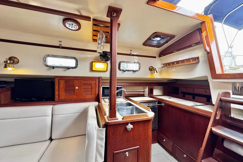 Slide: The Image of Interior of 1998 Island Packet 350 sailboat with kitchen and seating area. - 9